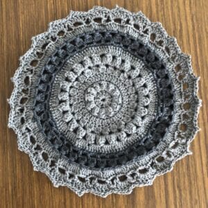 Grey crochet placemat on wood table