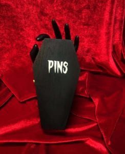 Black Coffin shaped pin box on a red background